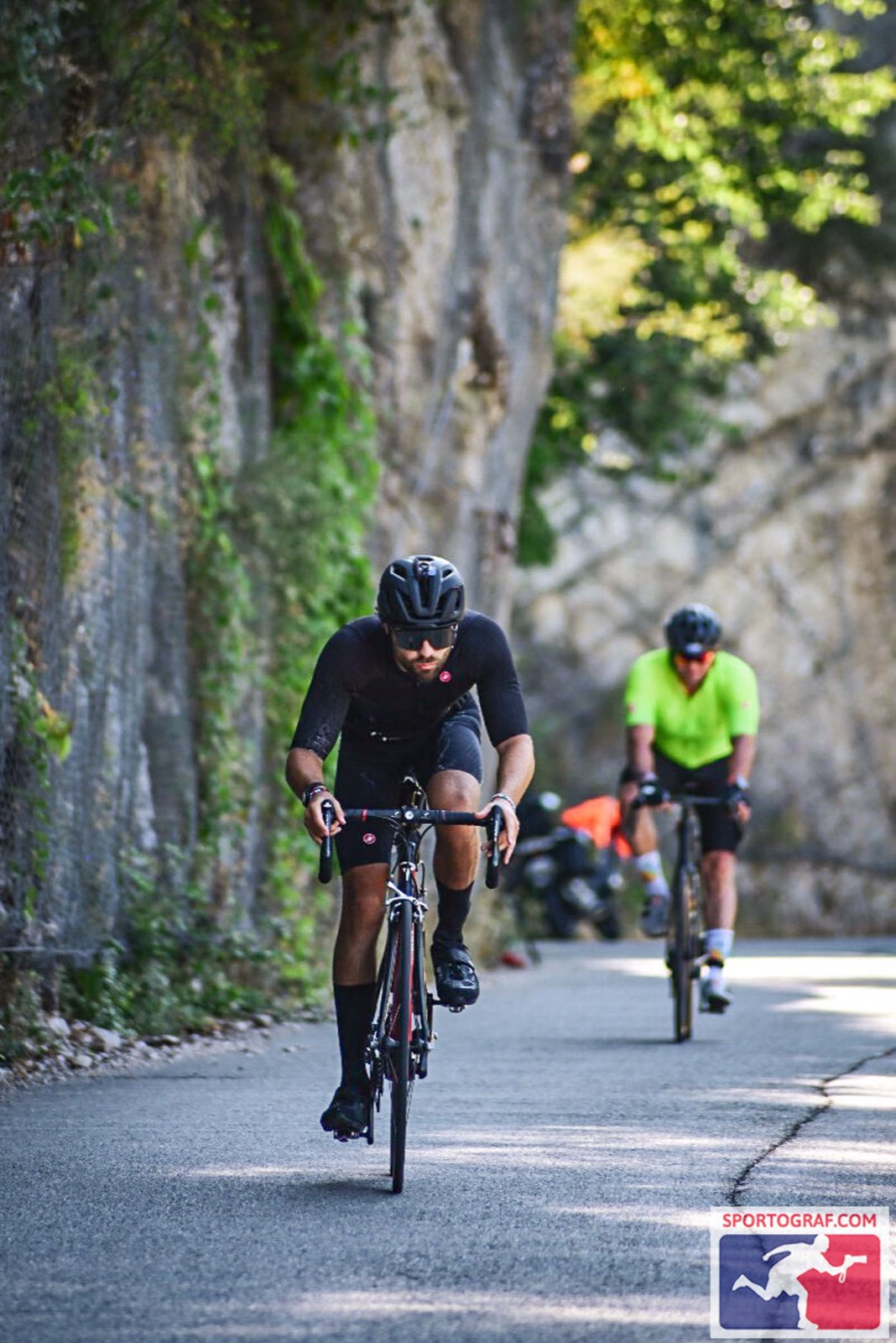 James Jackson on the bike leg of Ironman Nice, climbing past a rock face